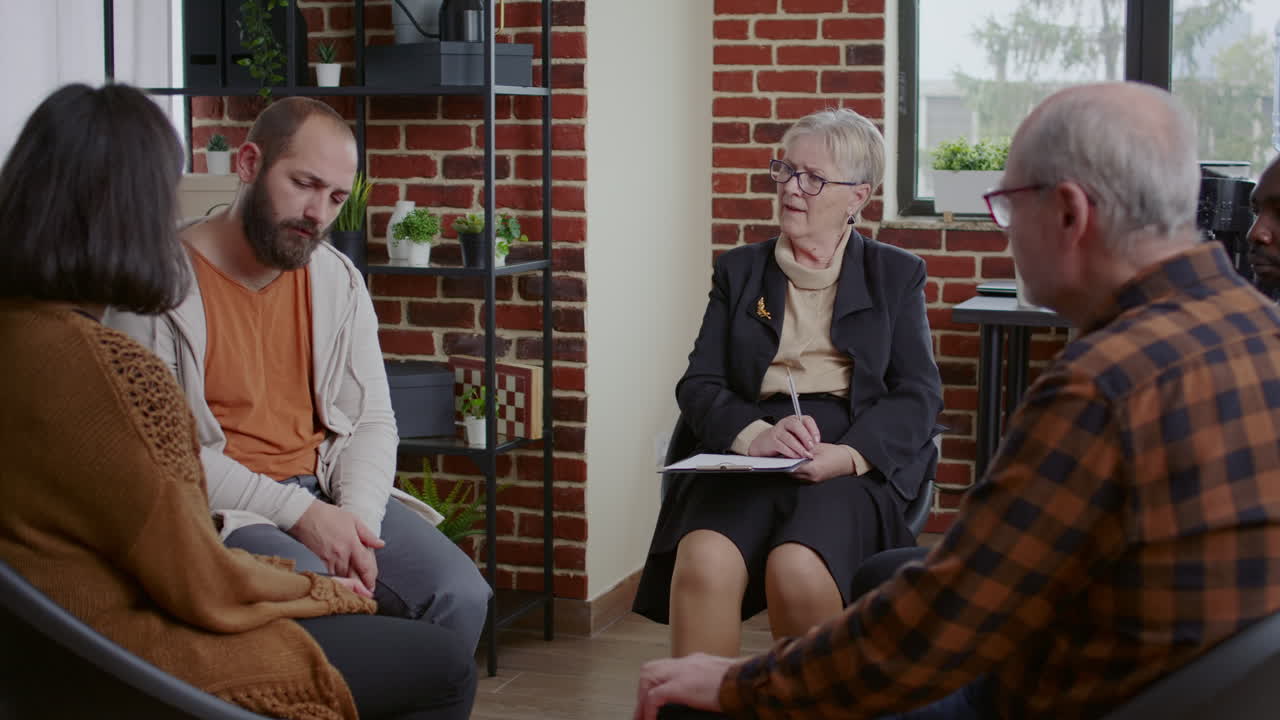 Man with depression making confession at aa therapy meeting with alcoholics people