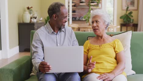 Senior-African-American-husband-and-mixed-race-wife-spending-time-and-working-at-home