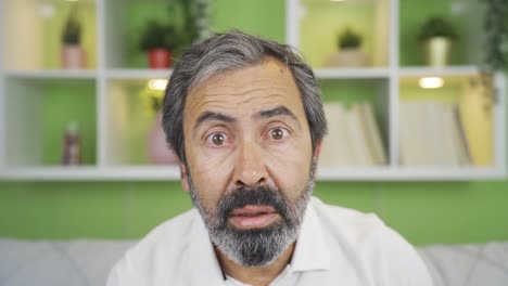 close-up mature man looks at camera confused.