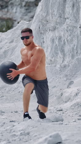 strength training on nature. sportive man exercising with medicine ball at nature vertical video