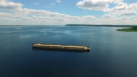 Rostiger-Lastkahn-Mit-Sand-Am-Fluss.-Aufgegebener-Kommerzieller-Gütertransport