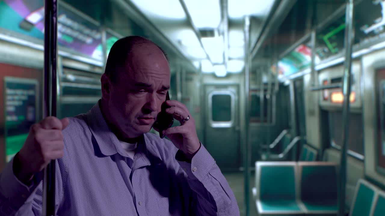 지하철을 타고 여행하는 동안 전화를 하는 남자