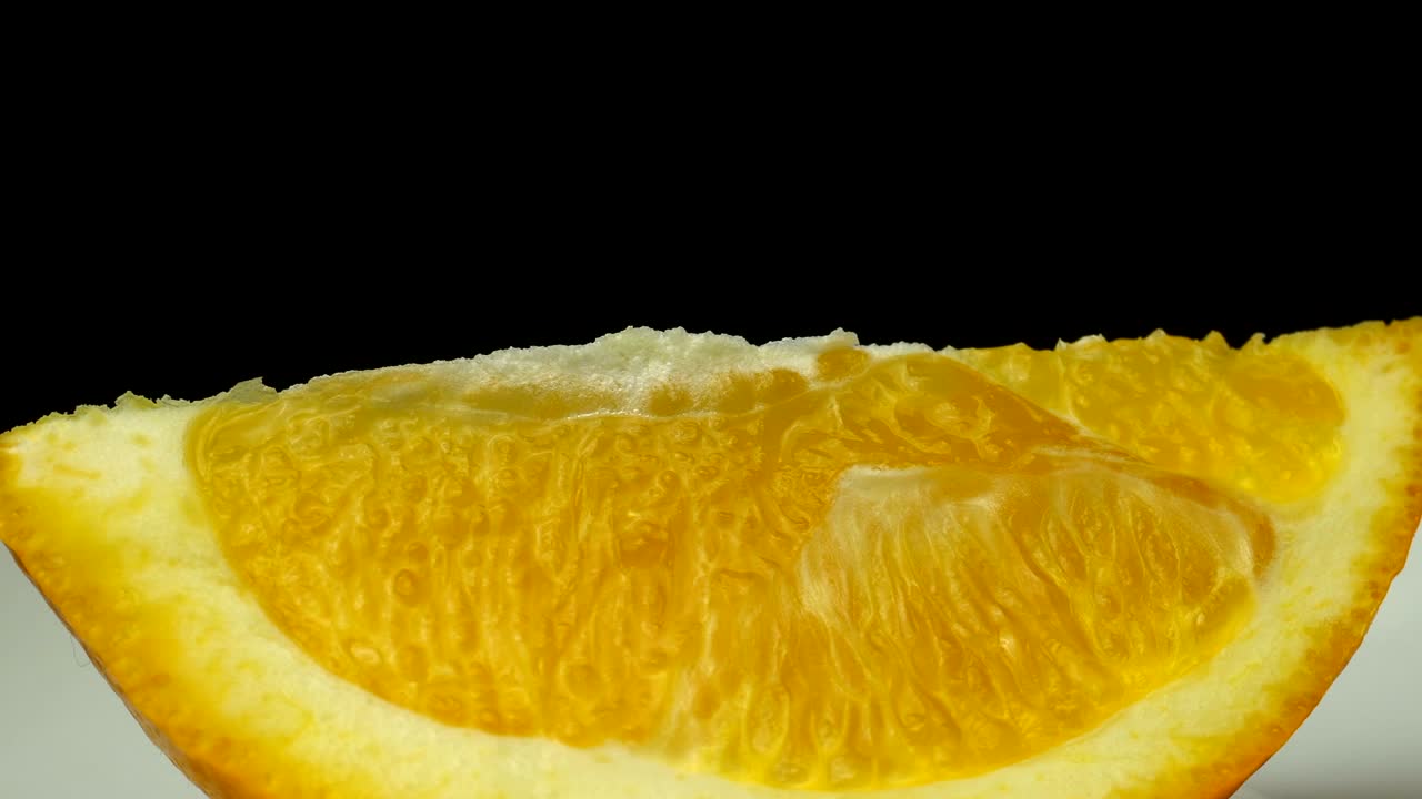 신선한 오렌지 과일 한 조각이  접시에서 확대되고 회전하고 있습니다.