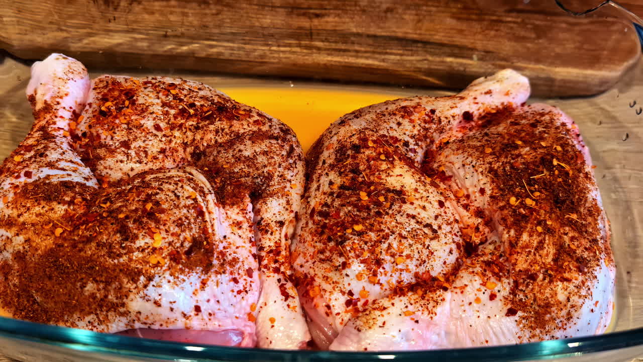 Seasoned chicken rests in glass dish, prepared for flavorful homemade cooking experience