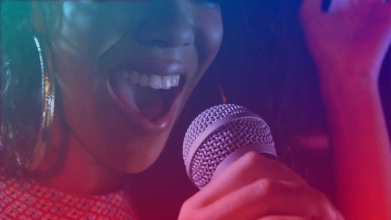 Animation of red and purple lights over biracial woman singing holding microphone