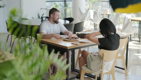 una pareja comiendo pizza en un restaurante.