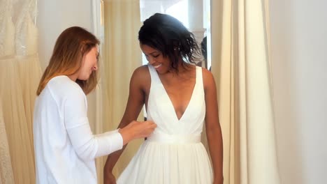 mujer probando el vestido de novia con la ayuda de un diseñador de moda