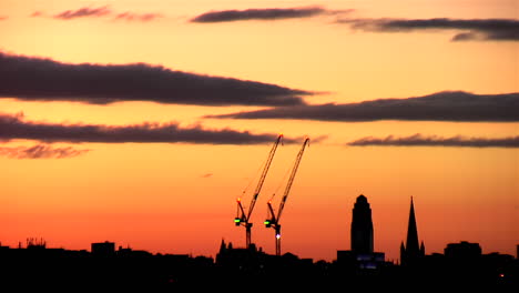 Lapso-De-Tiempo-De-Las-Nubes-Cúmulos-Que-Se-Desarrollan-Durante-Una-Puesta-De-Sol-De-Color-Naranja-Brillante-Sobre-Una-Silueta-De-La-Ciudad-De-Leeds,-Reino-Unido-En-Una-Noche-De-Verano