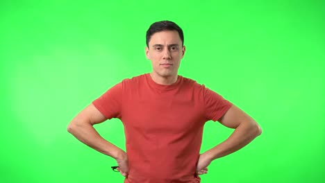 man posing and adjusting glasses on green screen