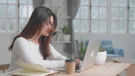 Happy Asian Girl Typing On Computer Keyboard Of A Laptop At Home, Video In 4K