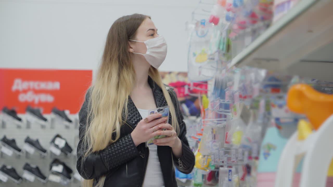 마스크를 착용 한 상점 에서 아기 제품 을 구매 하는 여자