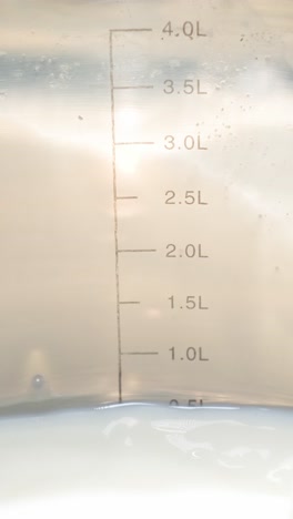 Carefully Pouring Fresh Milk into a Clear Measuring Cup for Accurate Ingredient Measurement this is a Detailed and Stunning Closeup View of Milk being Carefully Poured into a Clear and Transparent Measuring Cup