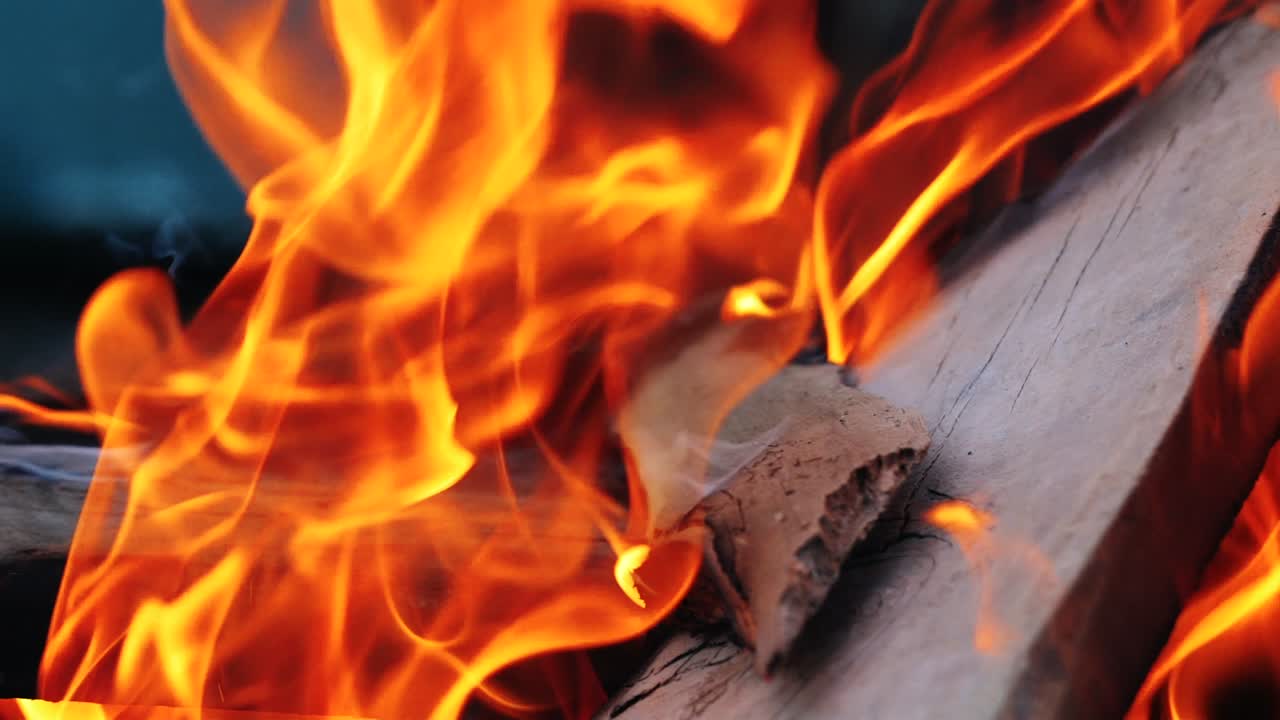 Close up of fireplace full of wood and fire. Slow motion