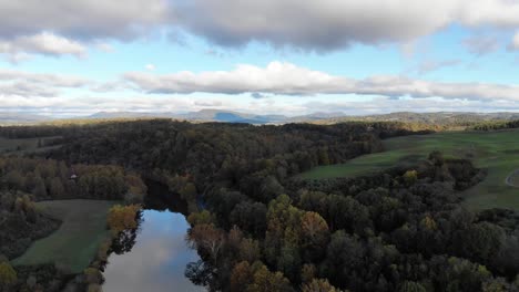 aerial footage over a river in the green hills of rural virginia, usa