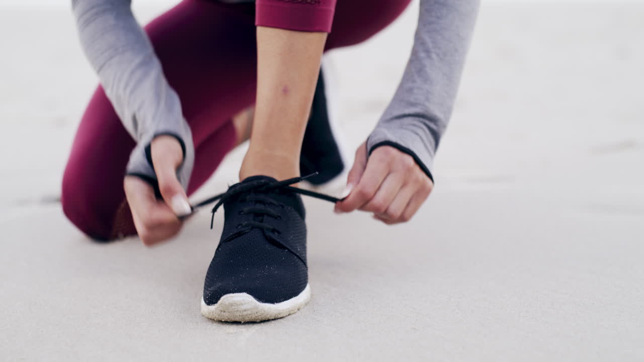 해변에서 달리기 신발을 고 있는 여자