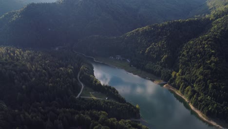 aerial pull back revealing a beautiful forest covered mountain valley, europe