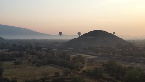 drone footage of hot air baloon flying over teotihuacan mexico during foggy sunrise, 4k