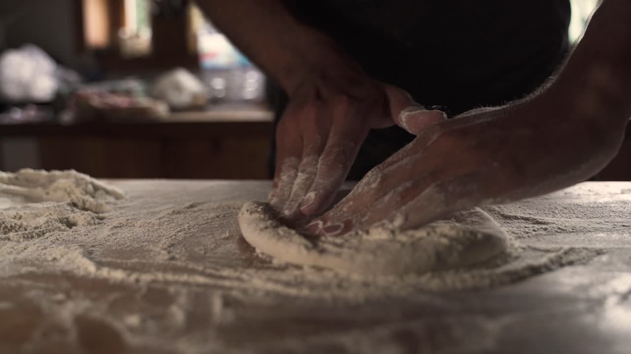 4K Chef uomo che impasta l'impasto della pizza fatta in casa su tavolo di legno 3