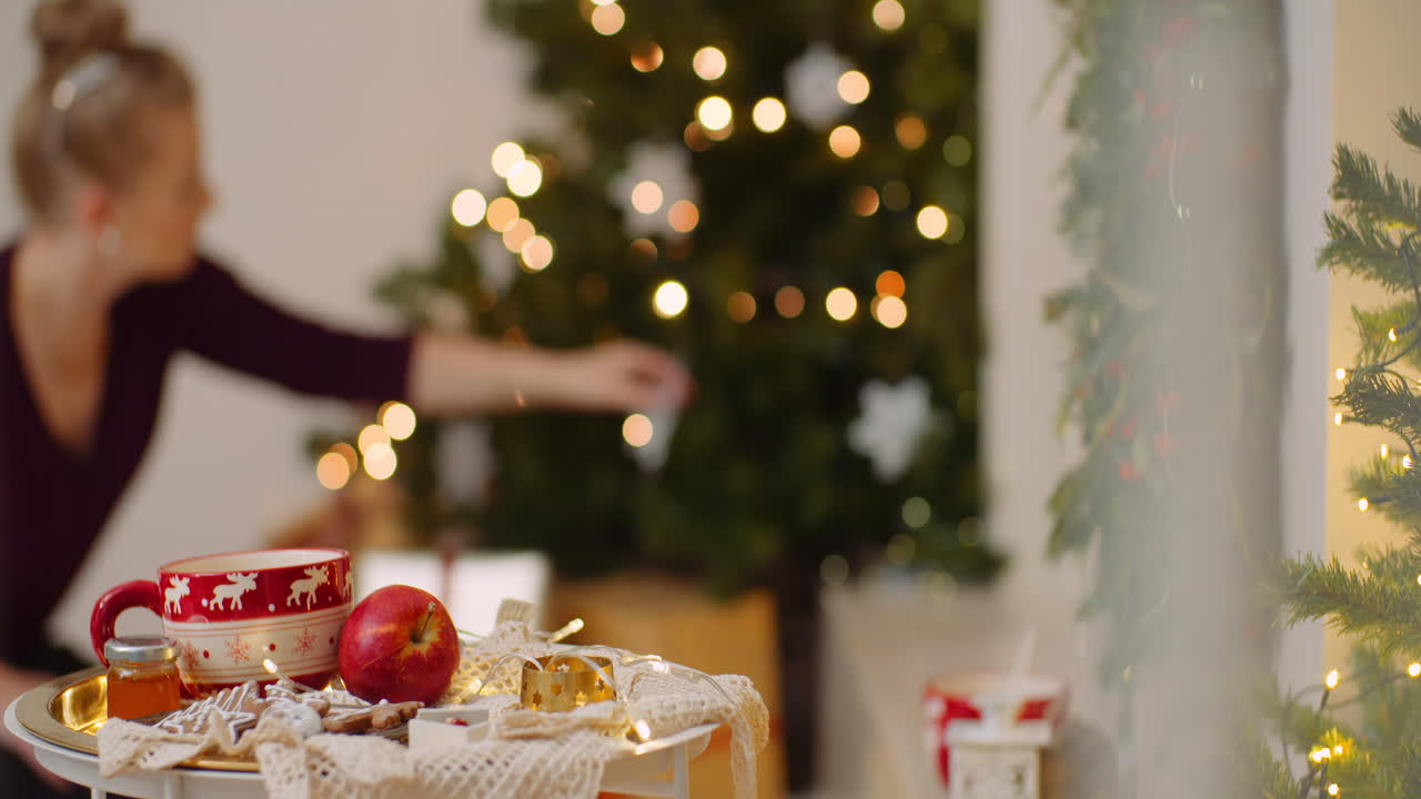 Mujer decorando el árbol de navidad en casa