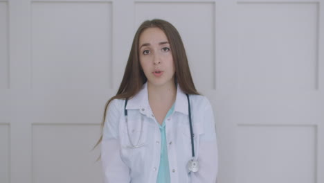 Smiling-young-female-doctor-wear-white-uniform-stethoscope-consulting-online-patient-via-video-call-looking-at-camera-speaking-cam-do-distance-video-chat-telemedicine-and-e-health-concept-webcam