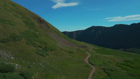 Aerial-cinematic-drone-early-morning-sunrise-people-hiking-trail-Grays-and-Torreys-14er-Peaks-Rocky-Mountains-Colorado-stunning-landscape-view-mid-summer-green-beautiful-snow-on-top-forward-movement