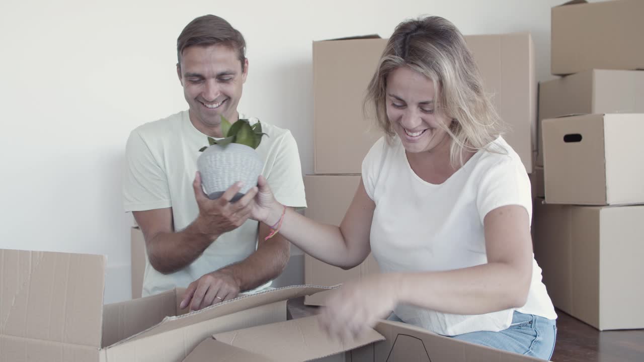 pareja feliz desempaquetando cosas en un nuevo apartamento