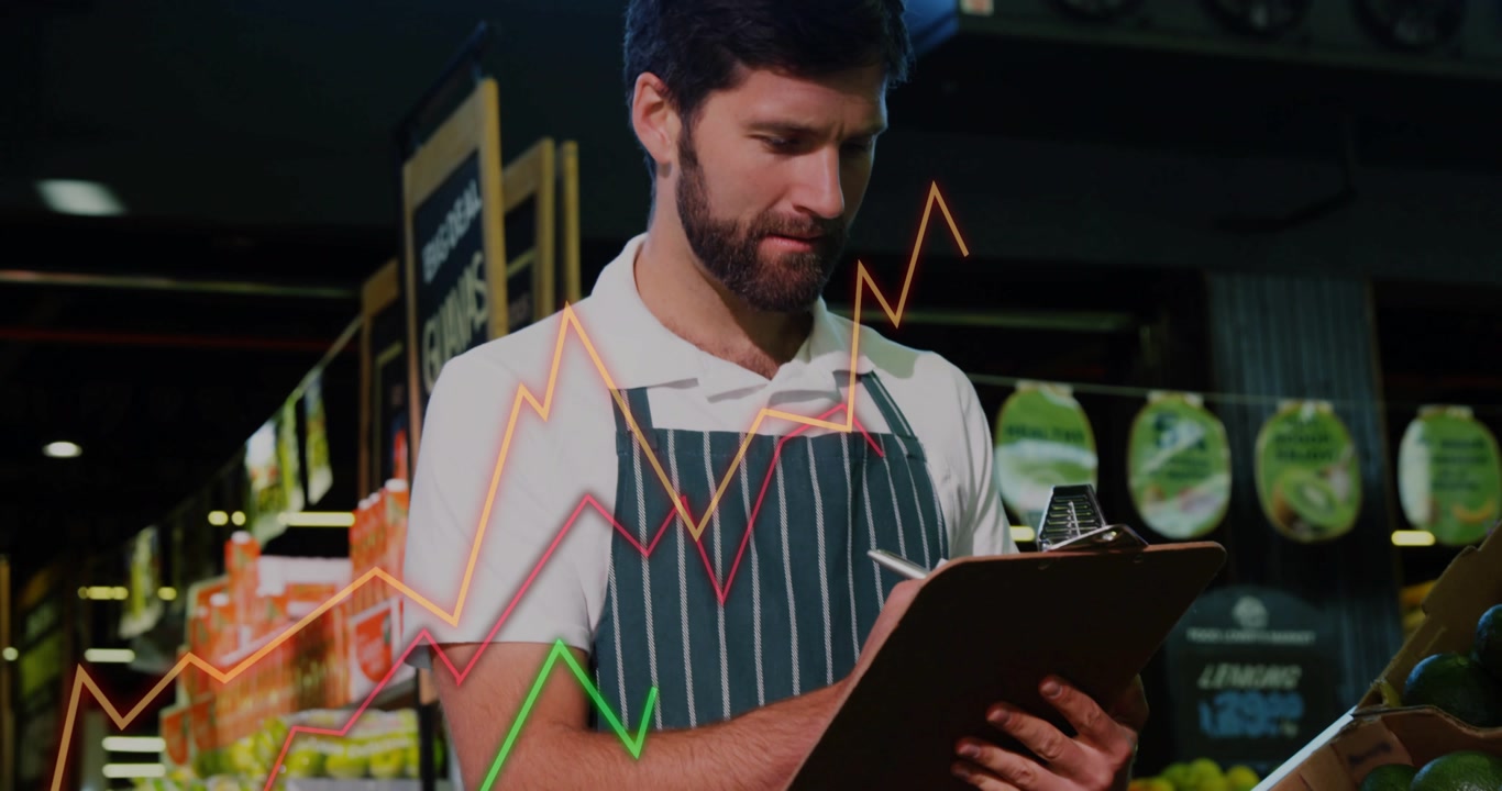 Camera pulling back, produce clerk inspecting avocados, noting stock while line charts crossing pad
