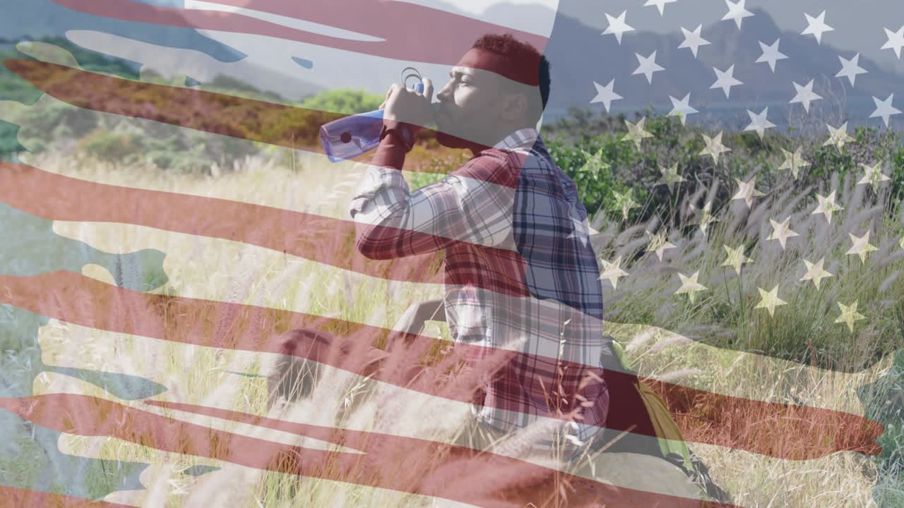animación de la bandera estadounidense sobre un hombre afroamericano bebiendo agua en las montañas