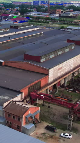 fotografía aérea de una extensa zona industrial con múltiples almacenes, un sistema ferroviario ocupado y camiones dispersos en medio de la actividad
