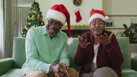 Feliz-Pareja-De-Ancianos-Afroamericanos-Con-Sombreros-De-Santa-En-Videollamada-En-Navidad