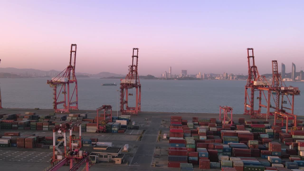 video aéreo de grúas y contenedores en el muelle al anochecer
