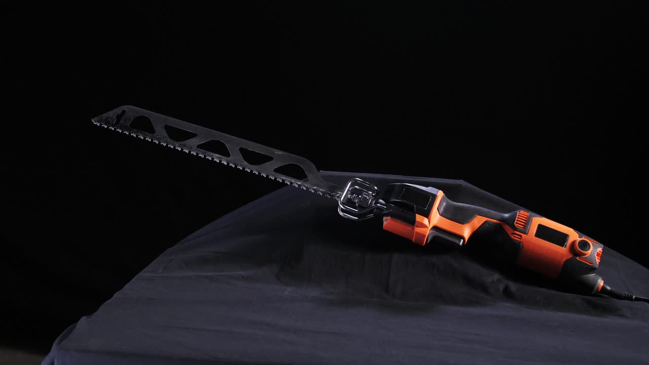 оранжевая и черная переменная пила на черном фоне