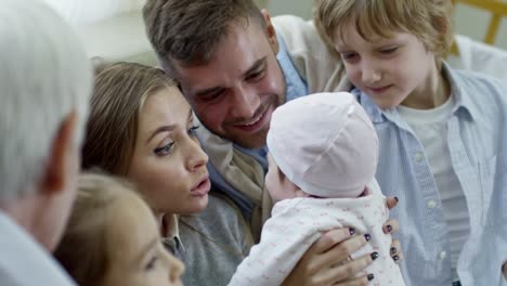 young parents and relatives playing with baby