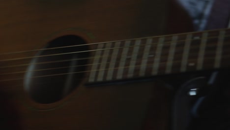 a close up of a young man is playing guitar, the camera pans right to show his chord hand