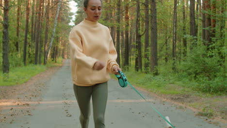 woman running with dog in forest