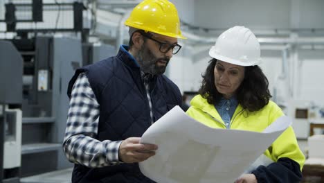 concentrated printing technicians inspecting plan of building