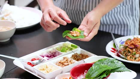 손으로 전통적인 태국 미앙  잎을 조립하고 재료를 넣습니다.