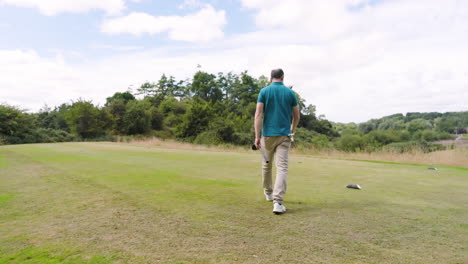 male golf players wearing uniforms, playing golf and walking with clubs on golf course, copy space