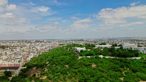 reval shot of falaknuma palace with trees and crowded residence buildings at engine bowli, falaknuma, hyderabad, telangana, india. day time, push back, drone shot, 4k.