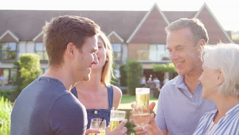 parents with adult offspring enjoying outdoor summer drink at pub