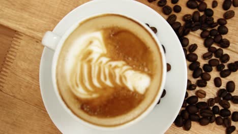 Close-up-of-coffee-cup-with-saucer-and-coffee-beans