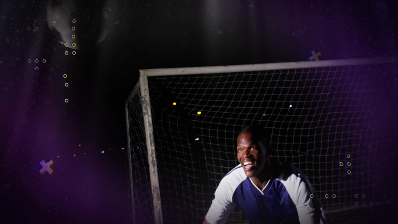 Male soccer goalkeeper leaning forward on field under lights showing sports technology data overlay