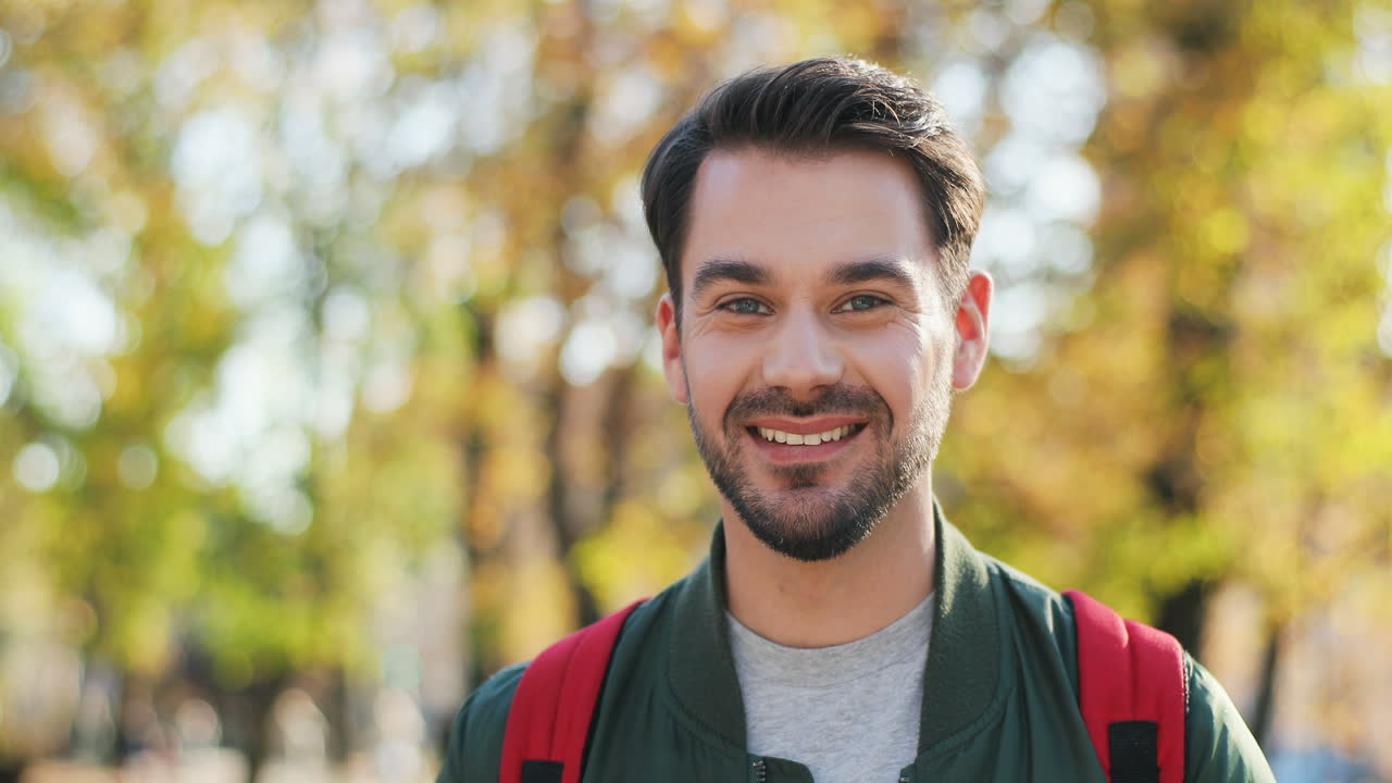 Close-up view of young Caucasian man with backpack looking aside