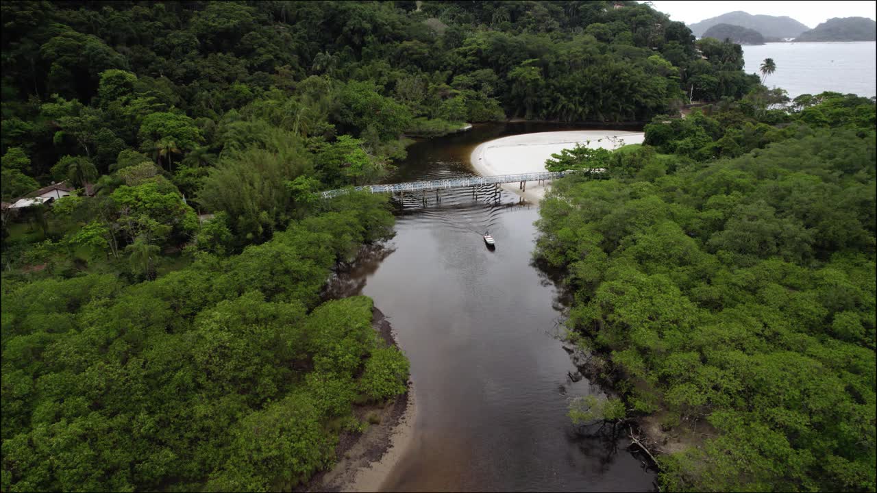 vista aérea descendente de un barco conduciendo por el río sahy, en el nublado brasil