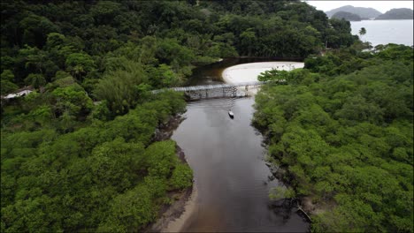 Absteigende-Luftaufnahme-Eines-Bootes,-Das-Auf-Dem-Fluss-Rio-Sahy-Im-Wolkigen-Brasilien-Fährt