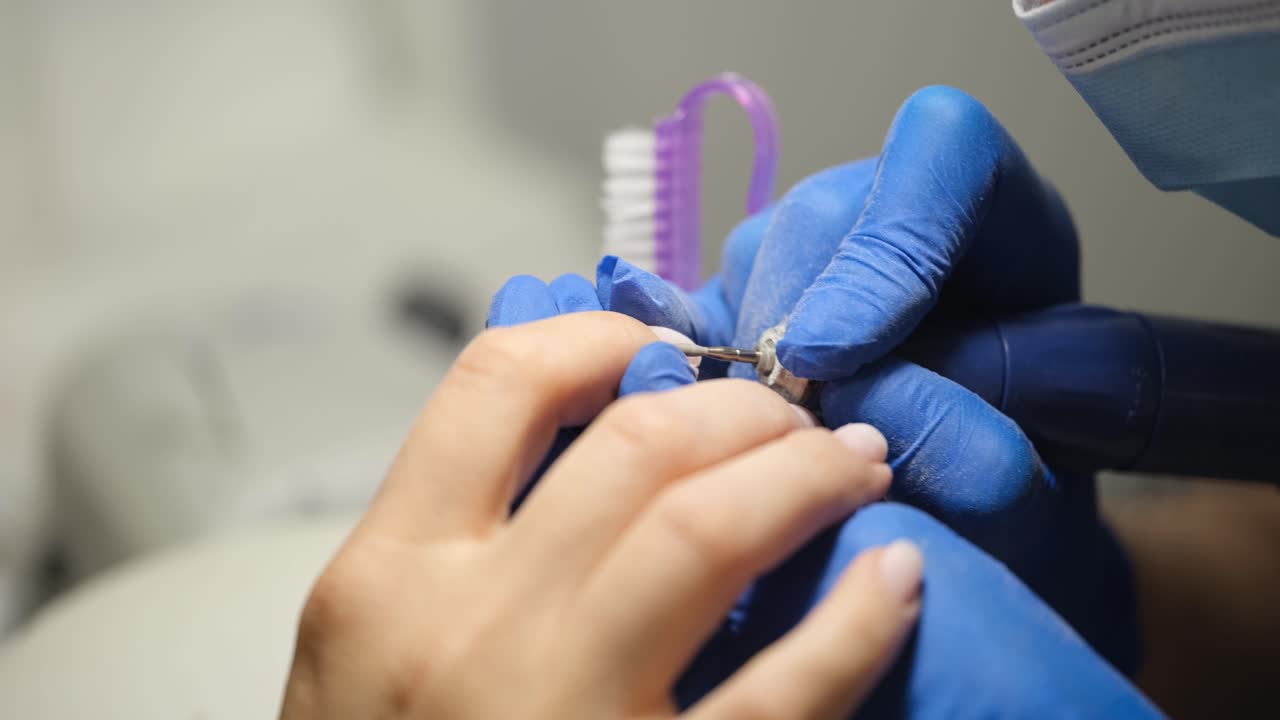 Manicure professionale con fresa elettrica in un salone di bellezza.