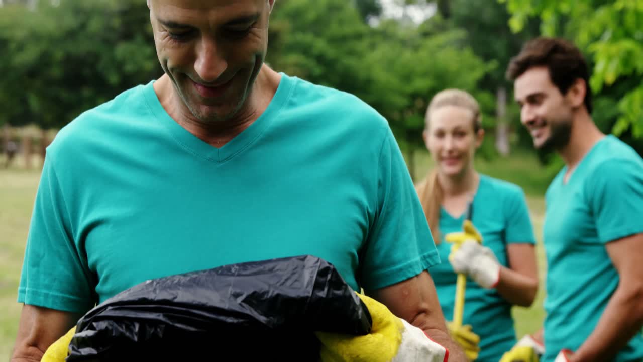 voluntario sosteniendo una bolsa desechable en el parque