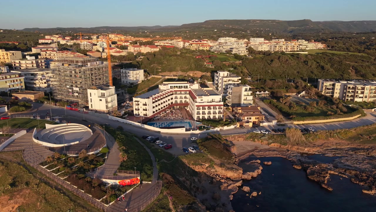 Hotel Calabona, hotel sul mare durante l'ora d'oro ad Alghero, Sardegna, Italia. - ripresa aerea