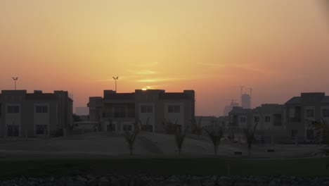 sunset in the evening, dusk, over homes in middle eastern city of dubai - united arab emirates