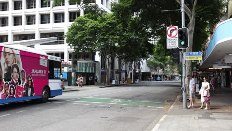 a colorful bus drives across a city street